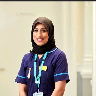 Photograph of Asma Pandor in dark blue nursing uniform with blue admiral nurse lanyard