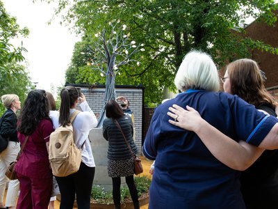 Staff and patients gathered around memory tree